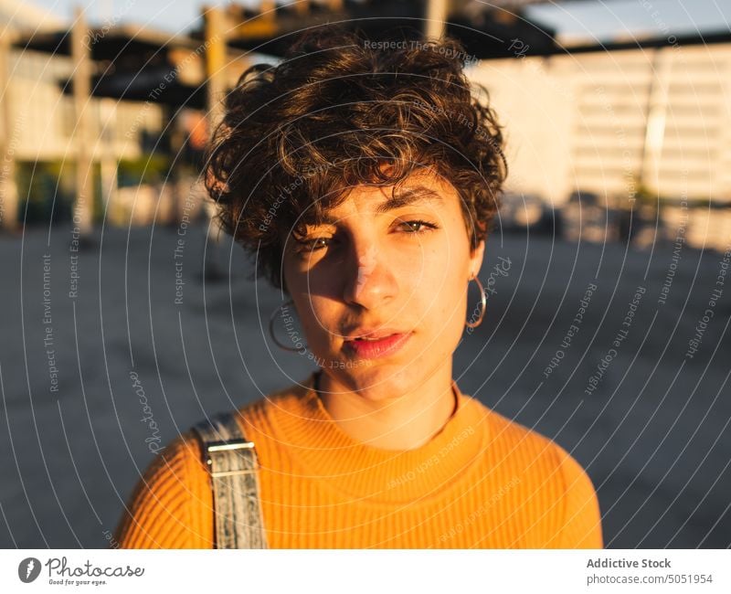 Nachdenkliche Frau auf sonniger Straße stehend nachdenklich besinnlich Windstille Sonnenlicht lässig Schatten Großstadt urban Persönlichkeit allein Kurze Haare