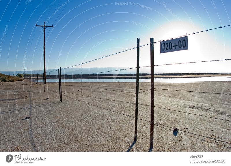 trostlos Himmel Zaun Stacheldraht Telefonmast Schlamm braun Bergkette Alamogordo New Mexiko blau blue sky Sonne sun fence barbed wire Schilder & Markierungen