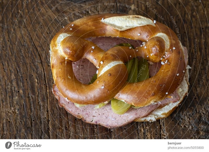 Leberkäse in einer Breze auf Holz Wurst lecker Hackbraten Brezel Sandwich Brett Brötchen Bayern geschnitten Brotzeit Laib Leberkaes Imbiss gebacken bayerisch