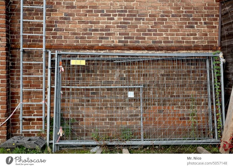 Betriebsgelände Hinterhof Baustelle Bauzaun Leiter Gebäude Fassade Lagerplatz Außenaufnahme abgestellt Material Absperrgitter Gitterzaun Feuerleiter Mauer