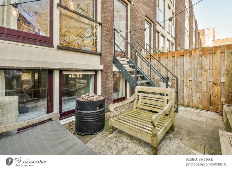 Hinterhof des Hauses mit Holzsitz Gebäude Terrasse wohnbedingt Stil verweilen Anwesen hölzern Wohnsitz Design Bank Licht Feuerstelle Zaun Treppenhaus gemütlich