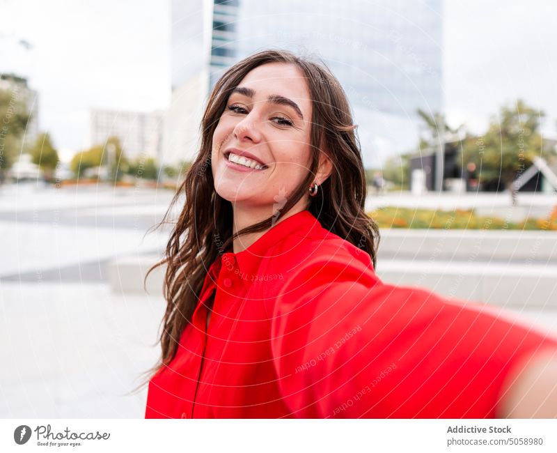 Glücklich stilvolle weibliche Aufnahme selfie auf der Straße Frau Selfie Lächeln urban Stil braune Haare jung lange Haare Funktelefon Selbstportrait sorgenfrei