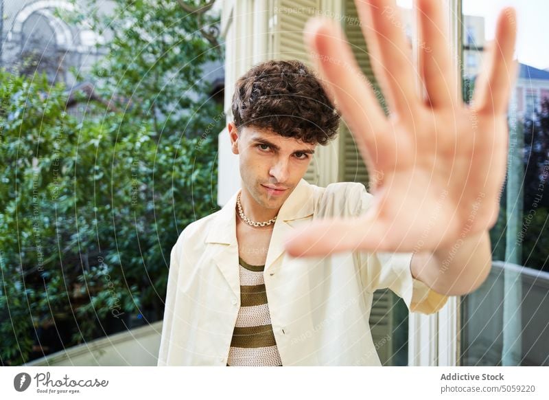 Mann versucht, die Kamera auf einer Dachterrasse mit der Hand zu verdecken Terrasse stoppen verweigern selbstbewusst ausdehnen leugnen nein Porträt männlich