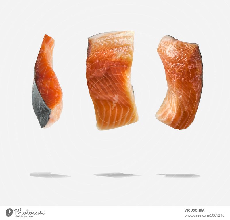 Fliegendes rohes Lachsfilet mit Schatten auf weißem Hintergrund. Lebensmittel Levitation fliegen Fisch Filet weißer Hintergrund Objekt Diät frisch Gesundheit