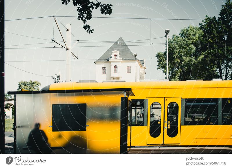 warten auf die Straßenbahn im Unterstand in Glas-Bauweise Schutz Station Verkehrswege Ankunft Mobilität Haltestelle Verkehrsmittel Schienenverkehr Oberleitung