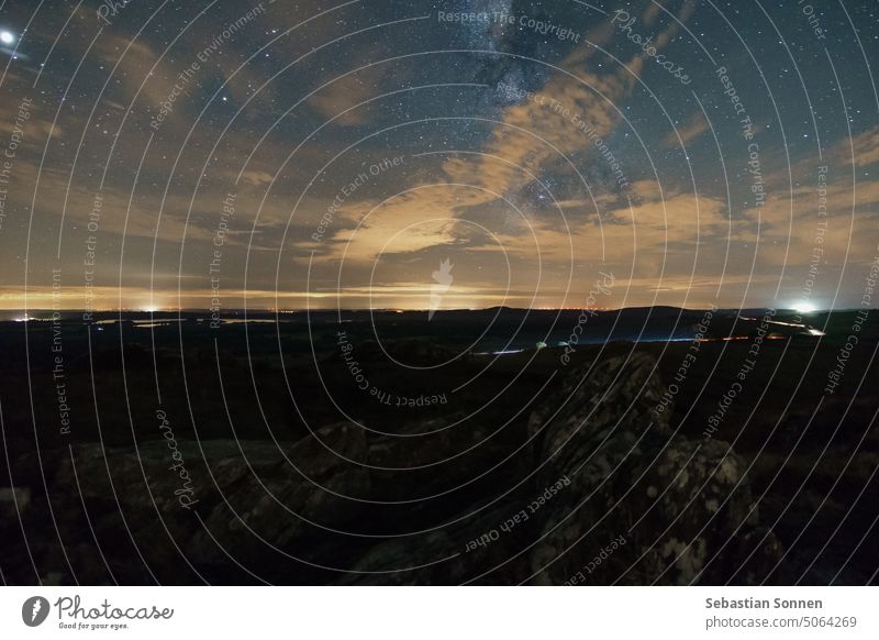 Felsenlandschaft auf dem Gipfel des Roc'h Trevezel bei Nacht mit Wolken, die die Milchstraße leicht verdecken, Parc naturel regional d'Armorique, Bretagne, Frankreich