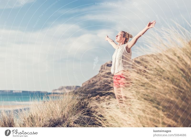 Freie glückliche Frau, die im Urlaub Sonne genießt. frei Freiheit sorgenfrei sich[Akk] entspannen Feiertag Natur Glück Sommer Wind Fröhlichkeit Strand jung