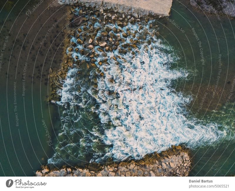 Schöner kleiner Wasserfall am Fluss Drome, der aus großen Steinen in einer Bergregion geformt wurde. Ein Wasserfall während des Sonnenuntergangs. Drohnenaufnahme aus der Luft