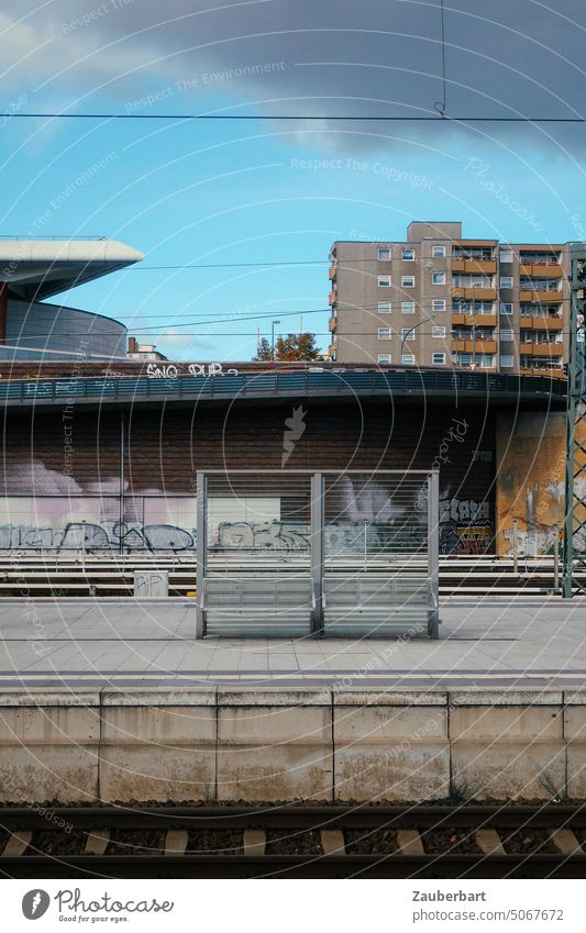 Bahngleis, Bahnsteig, Wartebank, im Hintergrund Wohnhäuser als städtisches Ensemble Bahnhof Bank WArtebank Mauer Überführung Wohnhaus Stadt Himmel S-Bahn warten