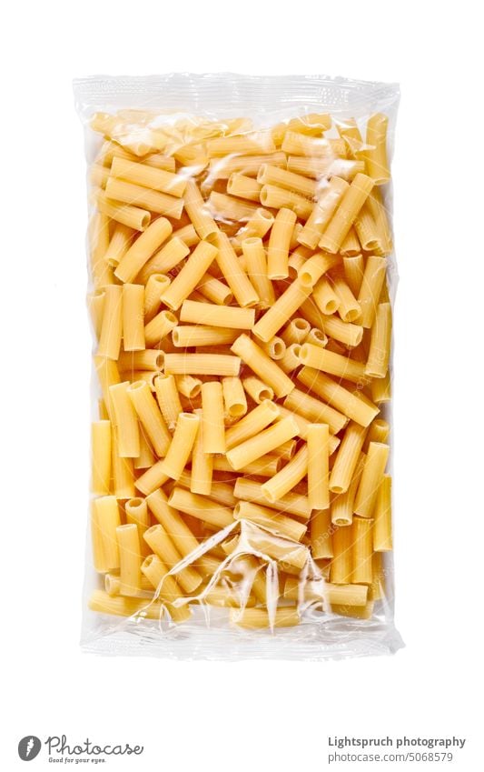 Penne-Nudeln in Plastikverpackung isoliert auf weißem Hintergrund. Spätzle Kunststoff Paket Tasche Plastiktüte Direkt darüber vereinzelt Hochwinkelansicht roh