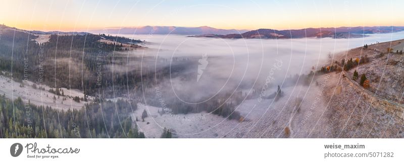 Berg Herbst nebligen Sonnenaufgang Panorama. Majestätische Morgennebel, November Tal Luftszene. Eis, Frost auf Gras. Herbst sonnige Landschaft, Waldhügel. Schöne tonale Perspektive