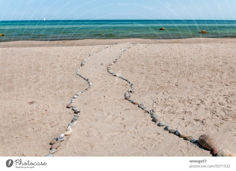 Mit Natursteinen gesäumter Strandweg zum Wasser Ostseestrand Meer Weg Steine Findlinge Horizont Segelboot Wolkenloser Himmel Küste Ferien & Urlaub & Reisen