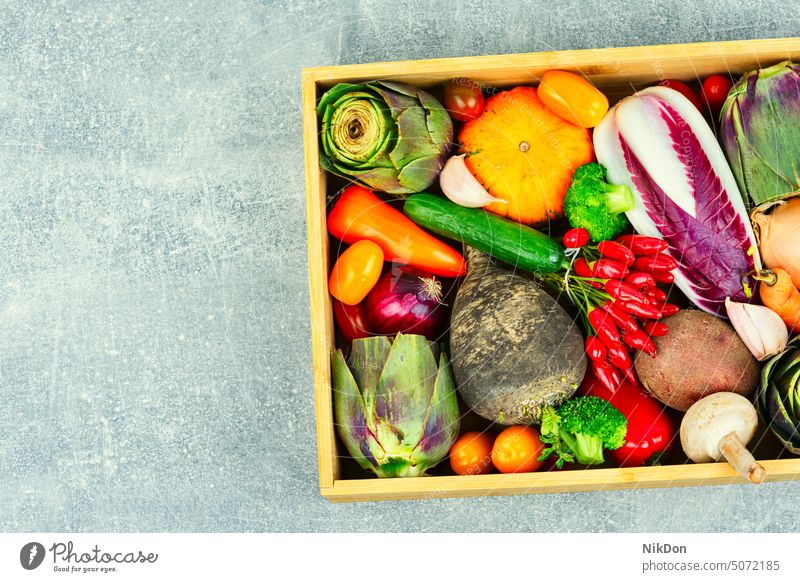 Set mit ungekochtem Gemüse in einer Holzkiste Menschengruppe Vegetarier Kulisse frisch roh Ernte Sortiment Kürbis Paprika Salatgurke Tomate Artischocke