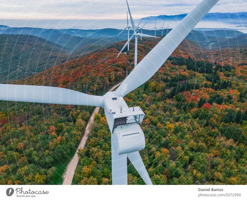 Nahaufnahme der Propeller einer Windkraftanlage an einem nebligen Morgen bei Sonnenaufgang. Grüne Energie. Windkraftanlage bei Morgennebel Luftaufnahme