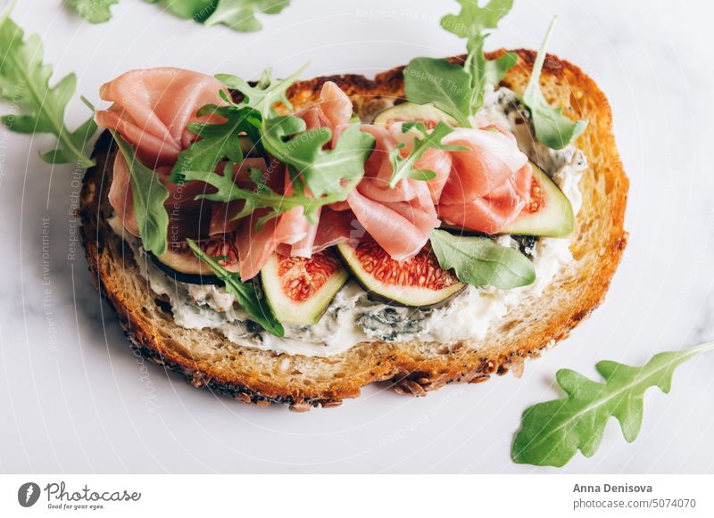 Offenes Sandwich mit Prosciutto und Feigen Belegtes Brot Rucola Rakete Blauschimmelkäse Schweinefleisch Käse Lebensmittel Mahlzeit Schinken Jamón Gesundheit