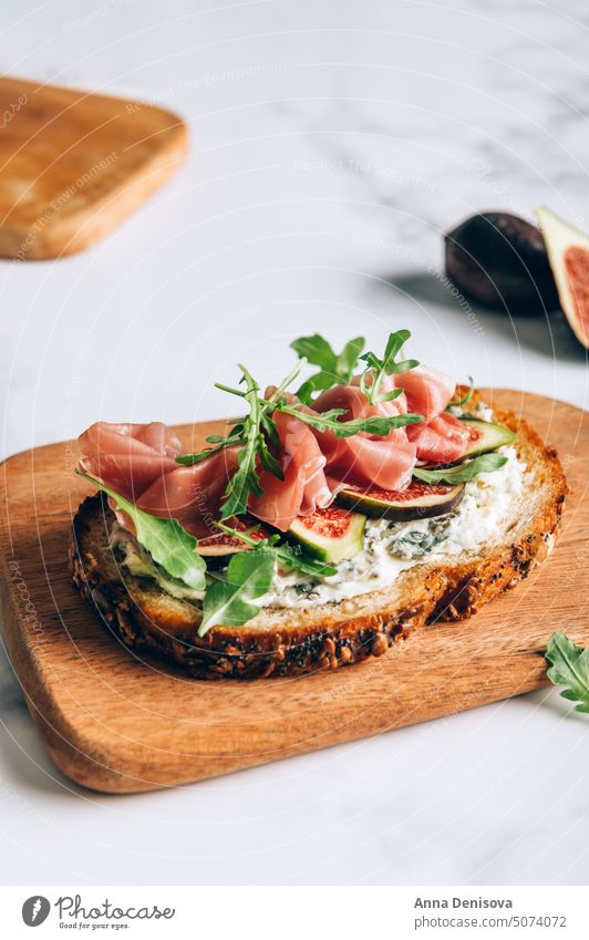 Offenes Sandwich mit Prosciutto und Feigen Belegtes Brot Rucola Rakete Blauschimmelkäse Schweinefleisch Käse Lebensmittel Mahlzeit Schinken Jamón Gesundheit