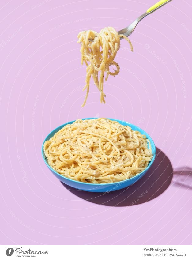 Nudeln essen mit einer Gabel, minimalistisch auf einem lila Hintergrund Schalen & Schüsseln hell cacio e pepe Kohlenhydrate Käse Farbe gekocht Textfreiraum