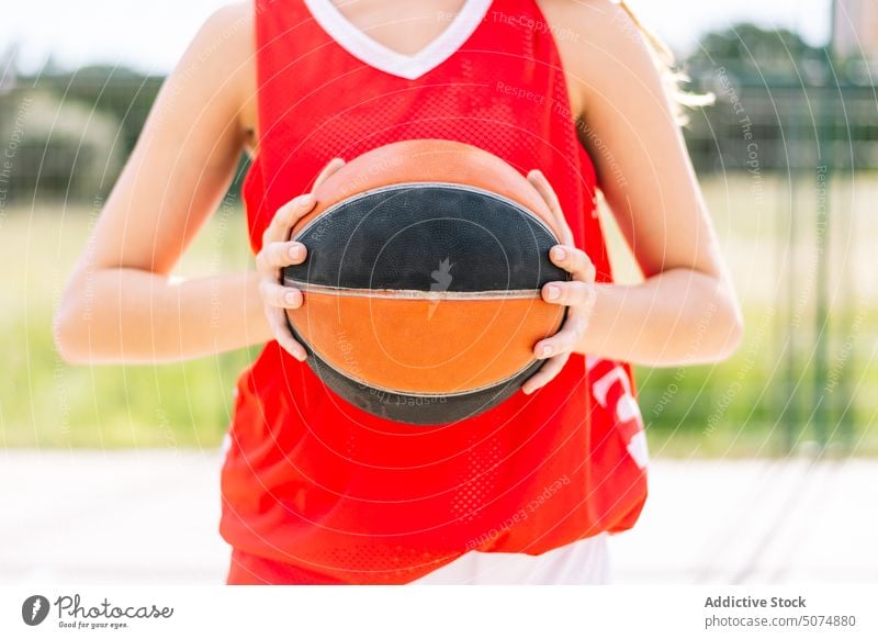 Anonymer weiblicher Basketballspieler mit Ball auf Sportplatz Sportlerin Spieler Streetball spielen unkenntlich Beschnittansicht gesichtslos Sportpark Tor Frau