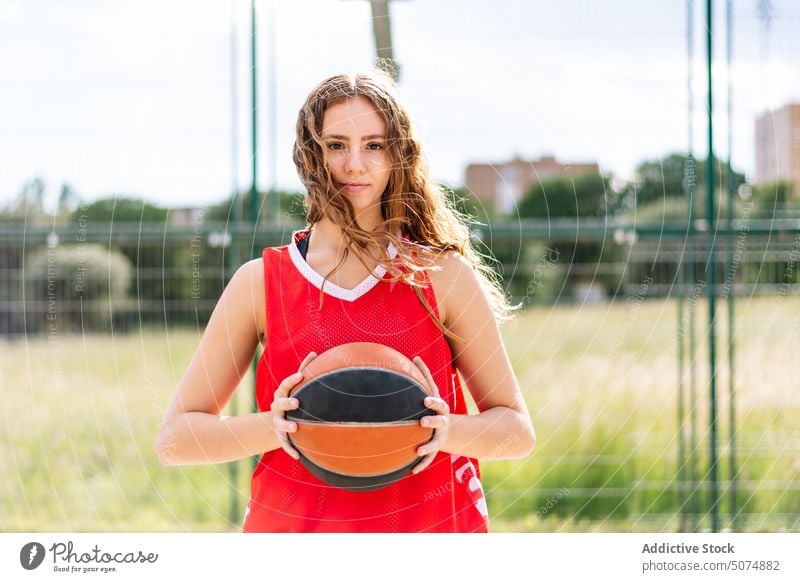 Weiblicher Basketballspieler mit Ball auf Sportplatz Sportlerin Spieler Streetball Reifen spielen Sportpark Tor Frau Himmel Sommer Hobby üben Training Aktivität