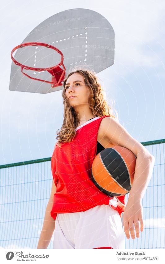 Weiblicher Basketballspieler mit Ball auf Sportplatz Sportlerin Spieler Streetball Reifen spielen Porträt Sportpark Tor Frau Himmel Sommer Hobby üben Training