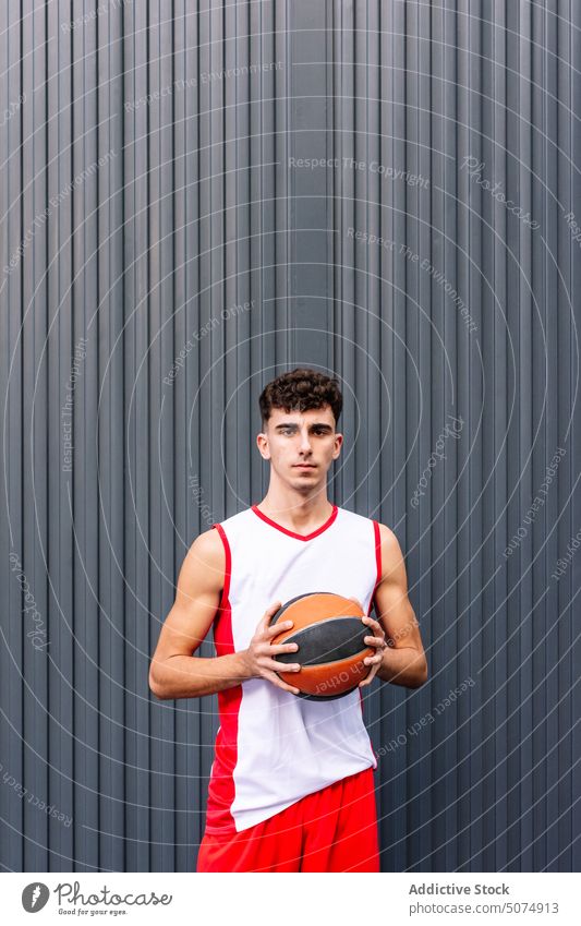 Männlicher Basketballspieler mit Ball vor dunklem Hintergrund Porträt Sportler Spieler Streetball Halt spielen Sportpark Tor Mann männlich Hobby üben Training