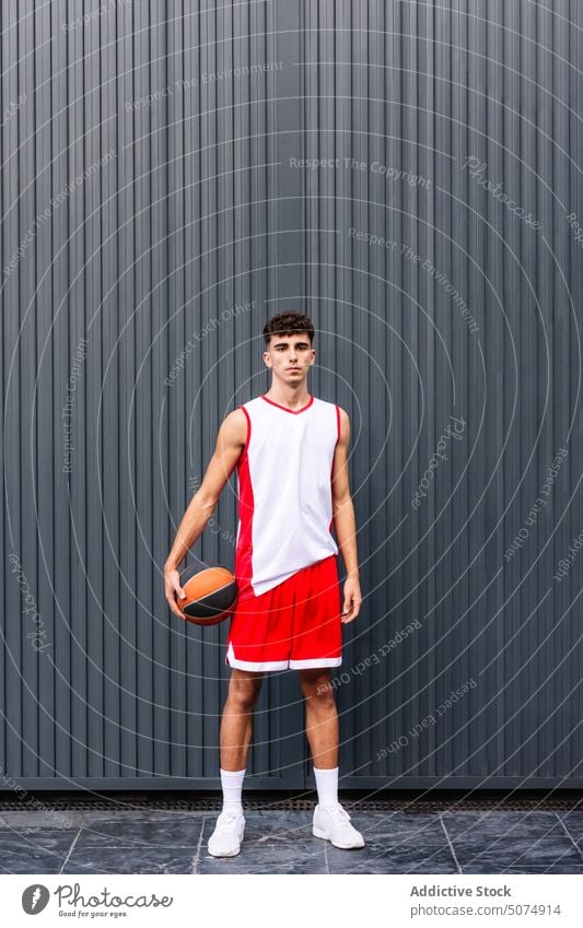 Männlicher Basketballspieler mit Ball vor dunklem Hintergrund Porträt Sportler Spieler Streetball Halt spielen Sportpark Tor Mann männlich Hobby üben Training