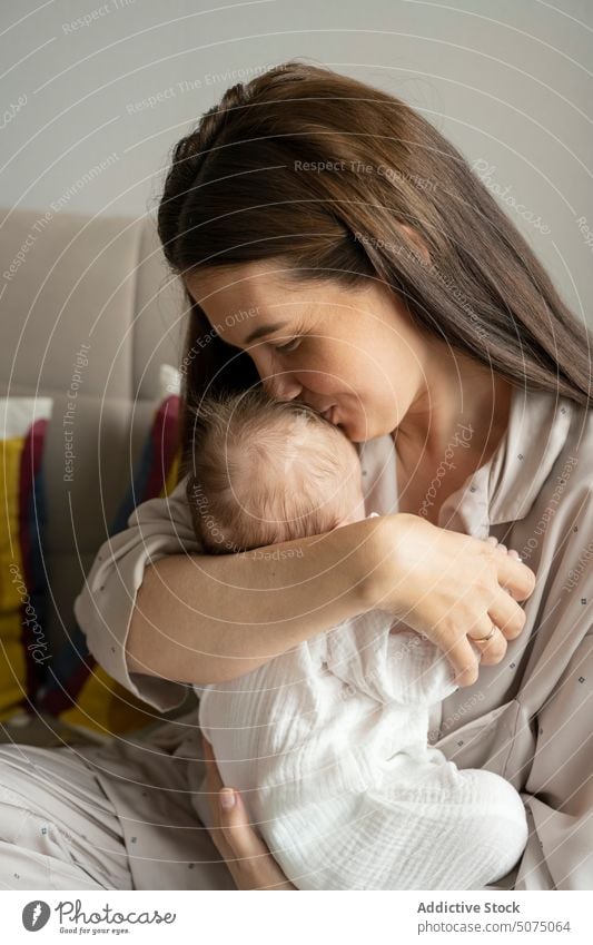 Mutter küsst Kleinkind und lächelt Baby schlafen Kuss Liebe Morgen heimwärts Glück Wochenende Lächeln Frau neugeboren Eltern Nachtwäsche Angebot Mama niedlich