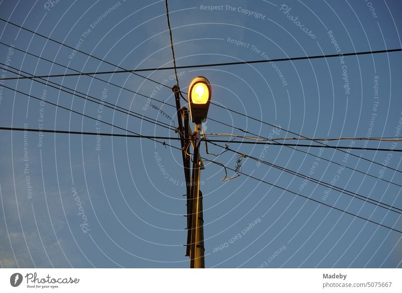 Stromleitungen mit Straßenbeleuchtung an einem Leitungsmast am Abend in Adapazari in der Provinz Sakarya in der Türkei straßenbeleuchtung strommast stromleitung