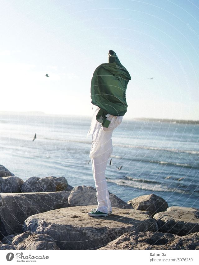 Stilvoller Mann am Strand gestylt Styler Stile stylisch stylen Pose Posen Angeber Meer Felsen Steine Küste Küstenlinie Wellen winken weiß Landschaft