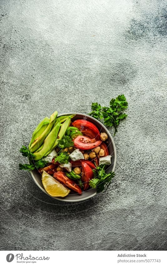 Gesunder Salat mit Bio-Gemüse Avocado Hintergrund Schalen & Schüsseln Käse Beton Koriander Salatgurke Besteck Diät essen Kichererbsen Essen Feta Lebensmittel