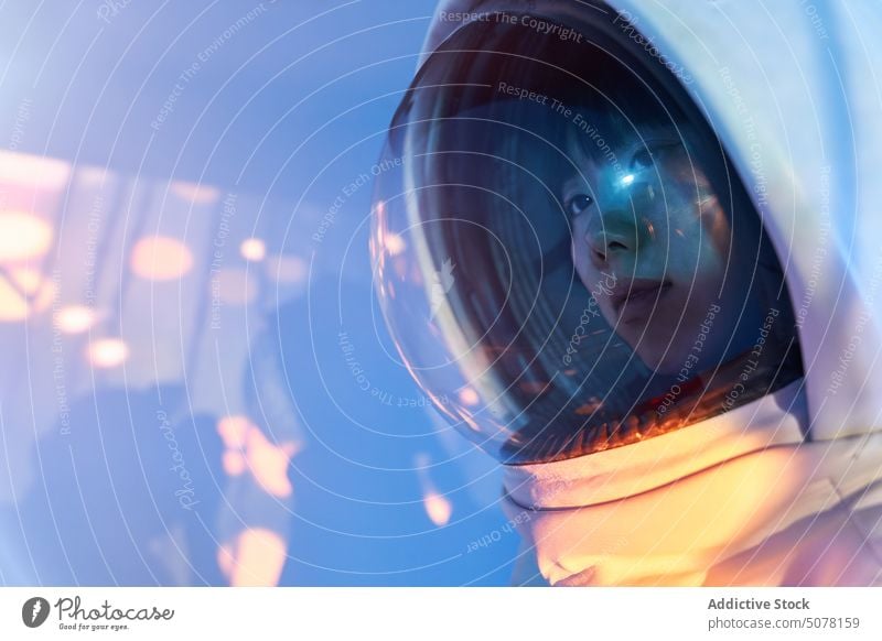 Ruhige Frau im Raumanzug Helm in Neonlicht Chinesisch Schutzhelm Astronaut träumen behüten Kosmonaut Konzept Tierhaut Windstille emotionslos futuristisch