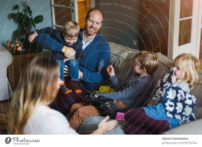 Glückliche junge Familie, die eine schöne Zeit zu Hause verbringt reales Leben echte Menschen Bonden im Innenbereich qualitätsvolle Zeit Kindererziehung Genuss