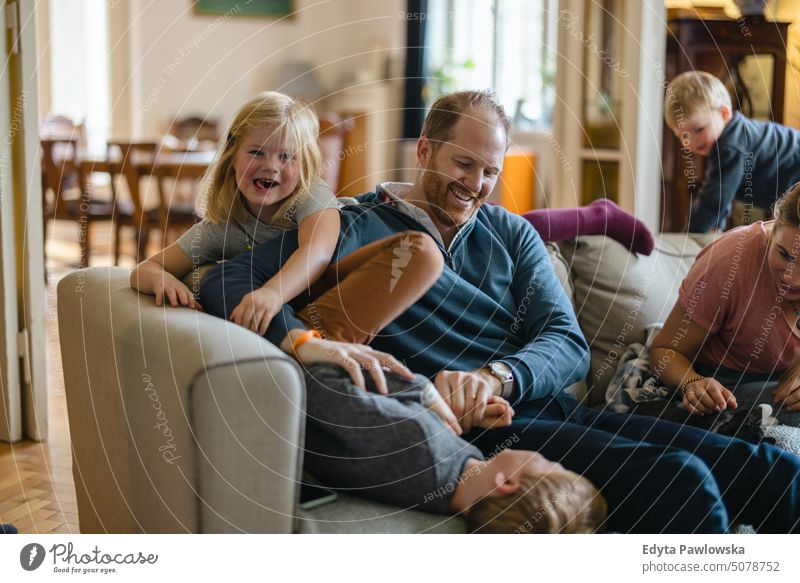 Glückliche junge Familie, die eine schöne Zeit zu Hause verbringt reales Leben echte Menschen Bonden im Innenbereich qualitätsvolle Zeit Kindererziehung Genuss