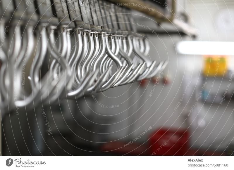 Fleischereihaken an einer Schiene - Metallhaken Maschine Handwerk Herstellung Produktion handwerkliche Produktion Arbeit Erwerb Küche arbeiten Manufaktur