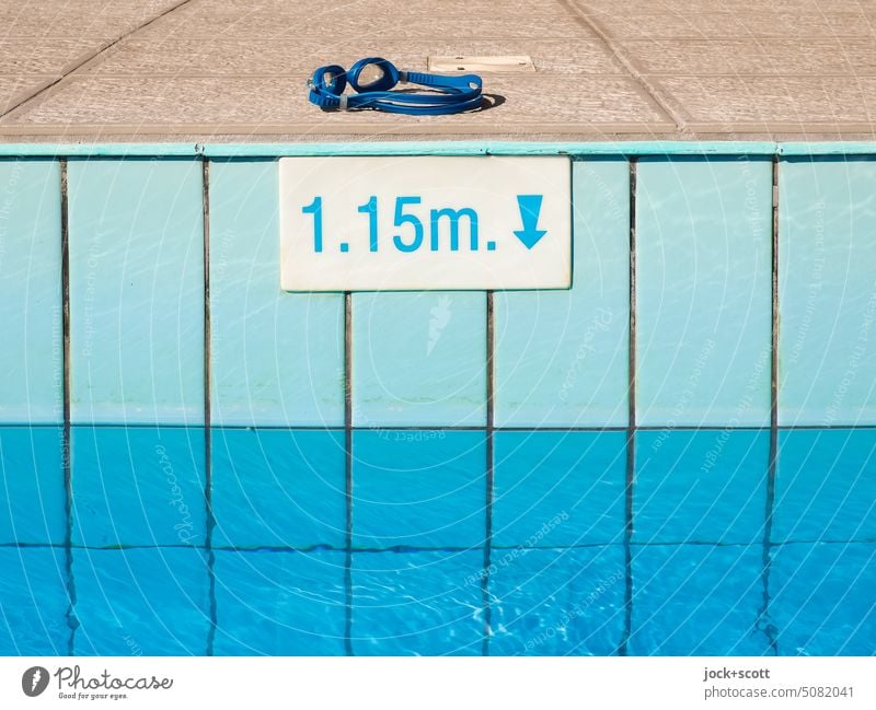 Schwimmbrille für das Schwimmbecken bei 1,15 Meter Wassertiefe Schwimmbad Beckenrand blau Fliesen u. Kacheln Menschenleer Sonnenlicht Strukturen & Formen