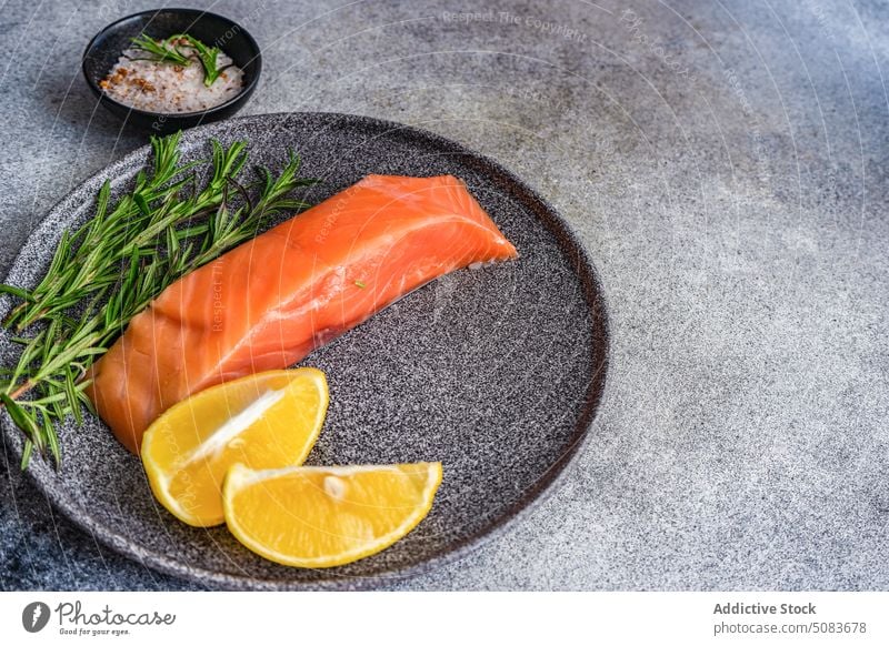 Gesunder Teller mit Lachsfisch essen Essen Fisch Lebensmittel Gesundheit Kraut Zitrone Mahlzeit Rosmarin Salz Scheibe Gewürz Steinplatte Ernährung kulinarisch