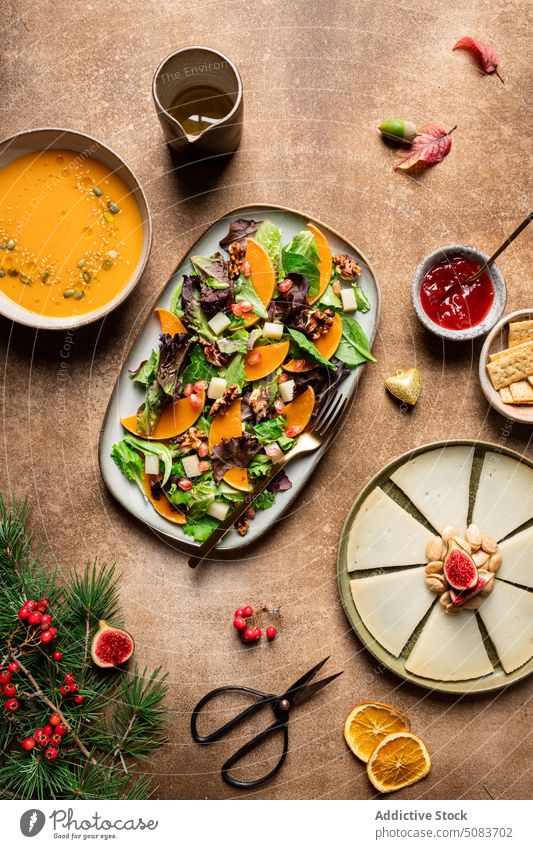 Teller mit vegetarischem Salat zum Mittagessen Salatbeilage Kürbis Spinat Veganer Gemüse gesunde Ernährung dienen Samen Granatapfel Walnussholz Saucen Beeren