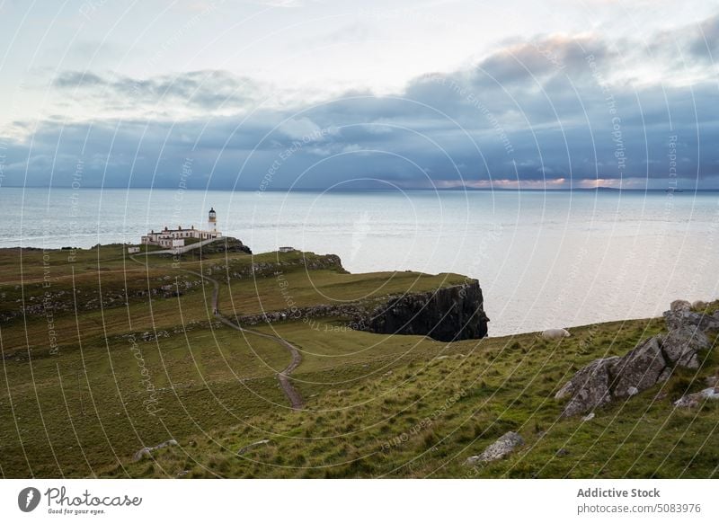 Scenic Blick auf Leuchtturm auf Klippe in der Nähe von ruhigen Meer unter bewölktem Himmel Landschaft MEER felsig Leuchtfeuer navigieren Tourismus Windstille