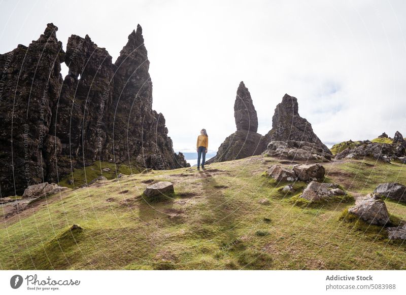 Lächelnde asiatische Frau steht gegen Berge in der Nähe von Steinen Wahrzeichen Tourist Berge u. Gebirge Nebel wolkig Natur bedeckt Glück Felsen Formation