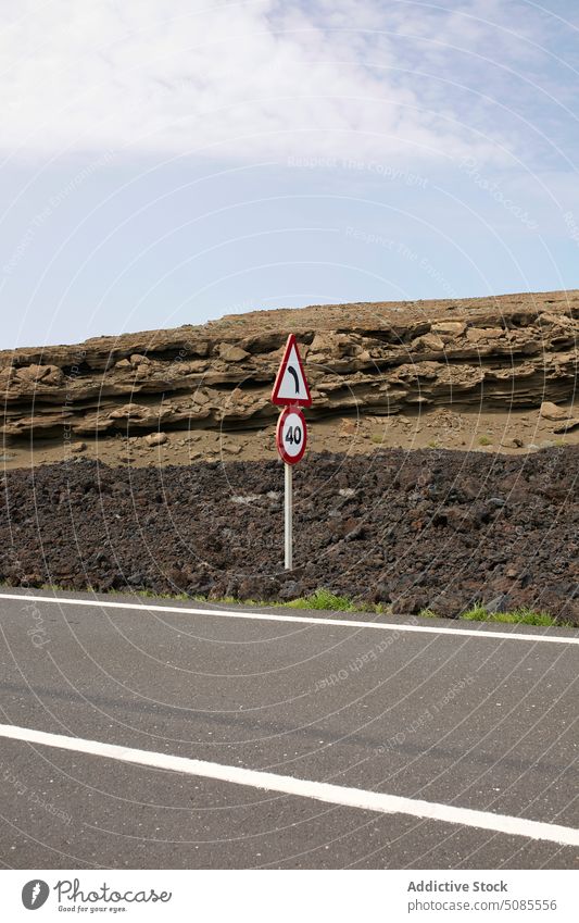 Asphaltstraße mit Beschilderung in einem vulkanischen Tal Straße Verkehrsschild Autobahn Route wild Natur Fahrbahn wüst Zeichen Ausflug Landschaft Weg tagsüber