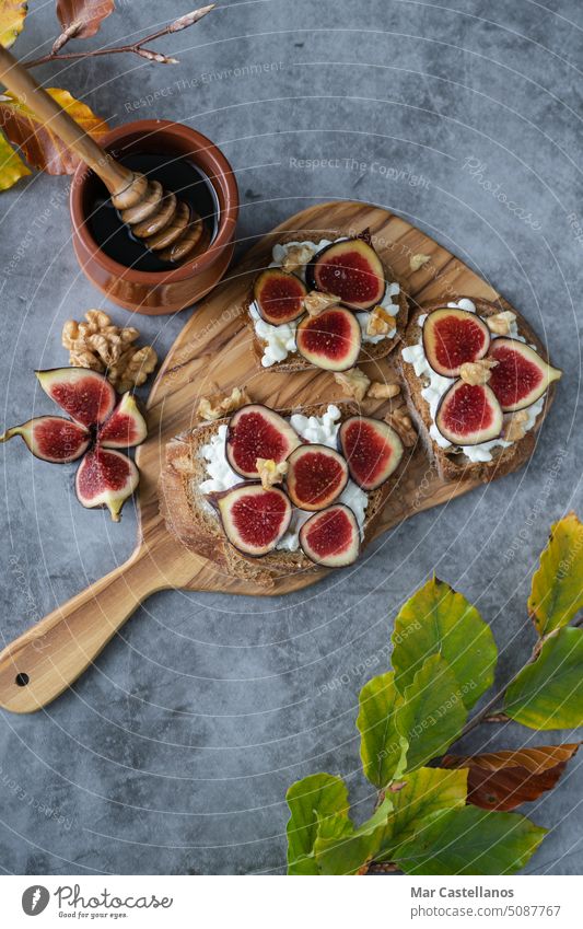 Toast mit Feigen, Käse und Honig auf einer Steinplatte. Platz zum Kopieren. Vertikales Foto. Liebling Muttern Zuprosten geschnitten Draufsicht Textfreiraum