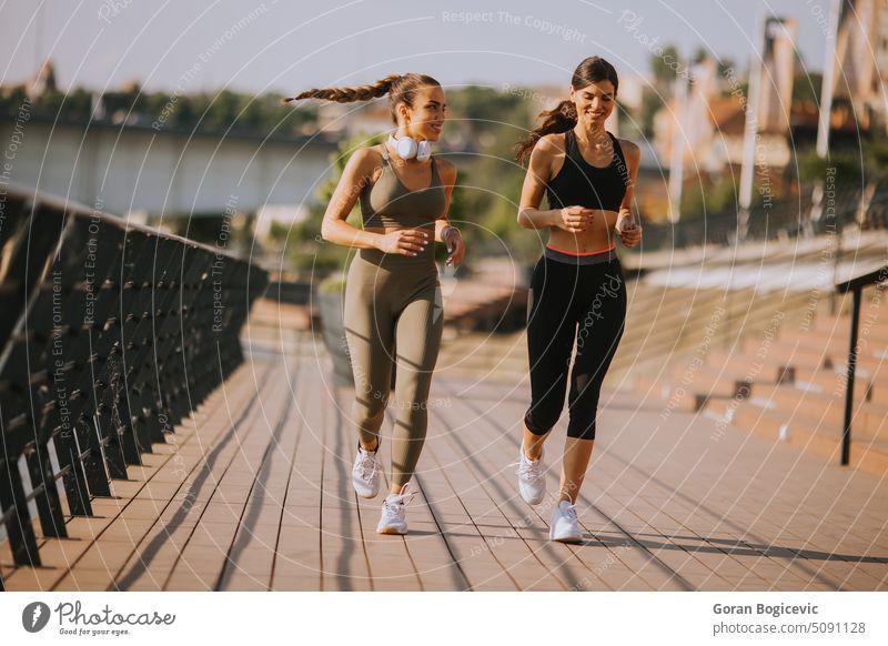 Junge Frau beim Lauftraining an der Flusspromenade Aktion aktiv Aktivität Erwachsener Athlet sportlich schön Kaukasier Großstadt Übung trainiert. passen Fitness