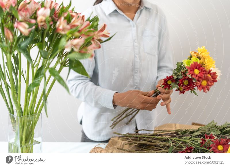 Anonyme Blumenhändlerin arrangiert einen Blumenstrauß Frau geschnitten Vorbau einrichten Handwerk Papier festlich präsentieren kreativ geblümt Floristik