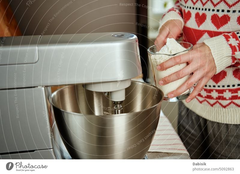 Frau, die zu Hause in der Küche kocht, benutzt einen elektrischen Mixer zur Zubereitung von Teig Essen zubereiten Geräte Rezept Feiertag Weihnachten Cookies