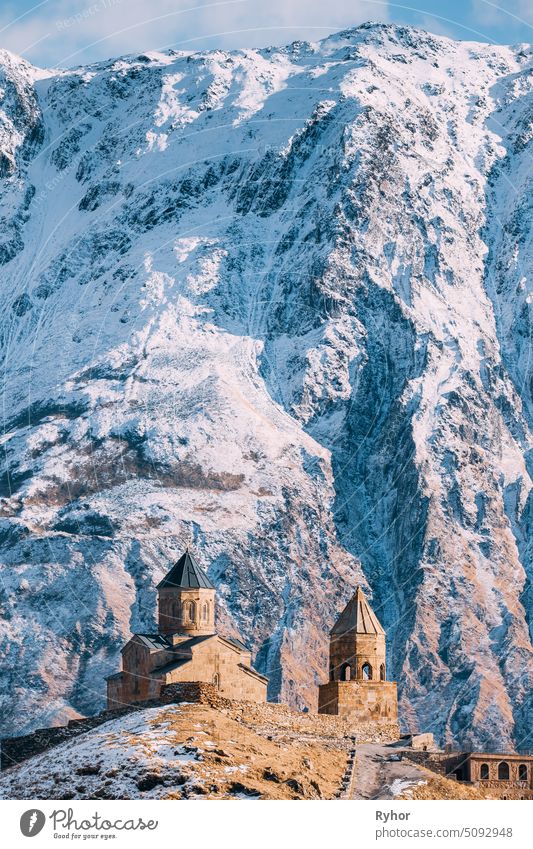 Stepantsminda, Georgien. Berühmte Gergeti Trinity Tsminda Sameba Kirche im frühen Winter Tempel Erbe Hügel Berge u. Gebirge Asien kazbegi