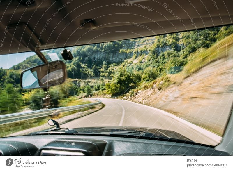 Blick von Fahrzeug Auto Interieur zu unscharfen Hintergrund der Straße in schnellen Bewegung. Dangerous Fast Motion Bewegung in Route. Sommer Asphalt auf Bergstraße Autobahn Autobahn. Reisen Konzept