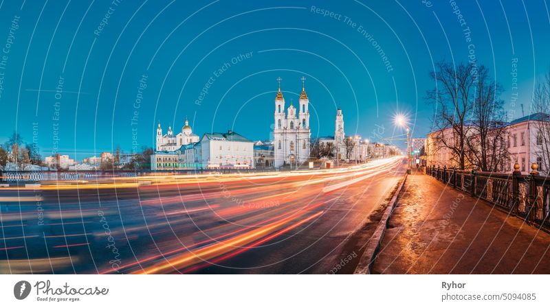 Vitebsk, Weißrussland. Abend-oder Nachtansicht von berühmten Wahrzeichen ist Mariä Himmelfahrt Kathedrale, Kirche der Auferstehung Christi und das alte Rathaus in der Straße Lichter Illumination. Traffic Light Trails