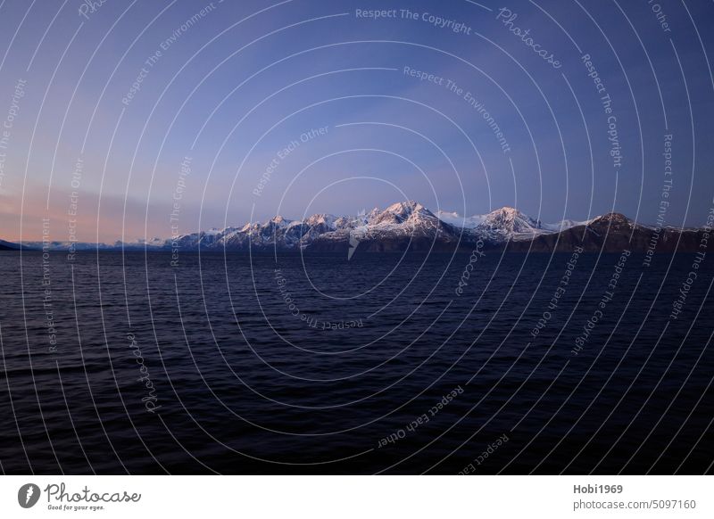 Schneebedeckte Berge an der Küste bei Alta in Norwegen schneebedeckt Meer Ozean Meerwasser kalt kälte Frost frostig weiß Himmel Horizont Fjord Salzwasser