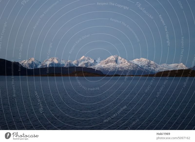 Schneebedeckte Berge an der Küste bei Alta in Norwegen schneebedeckt Meer Ozean Meerwasser kalt kälte Frost frostig weiß Himmel Horizont Fjord Salzwasser