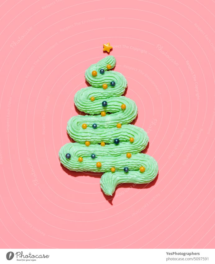 Weihnachtsbaum aus Buttercreme-Glasur isoliert auf einem rosa Hintergrund oben abstrakt Transparente Christbaumkugeln Bonbon Feier Weihnachten Farbe Konzept